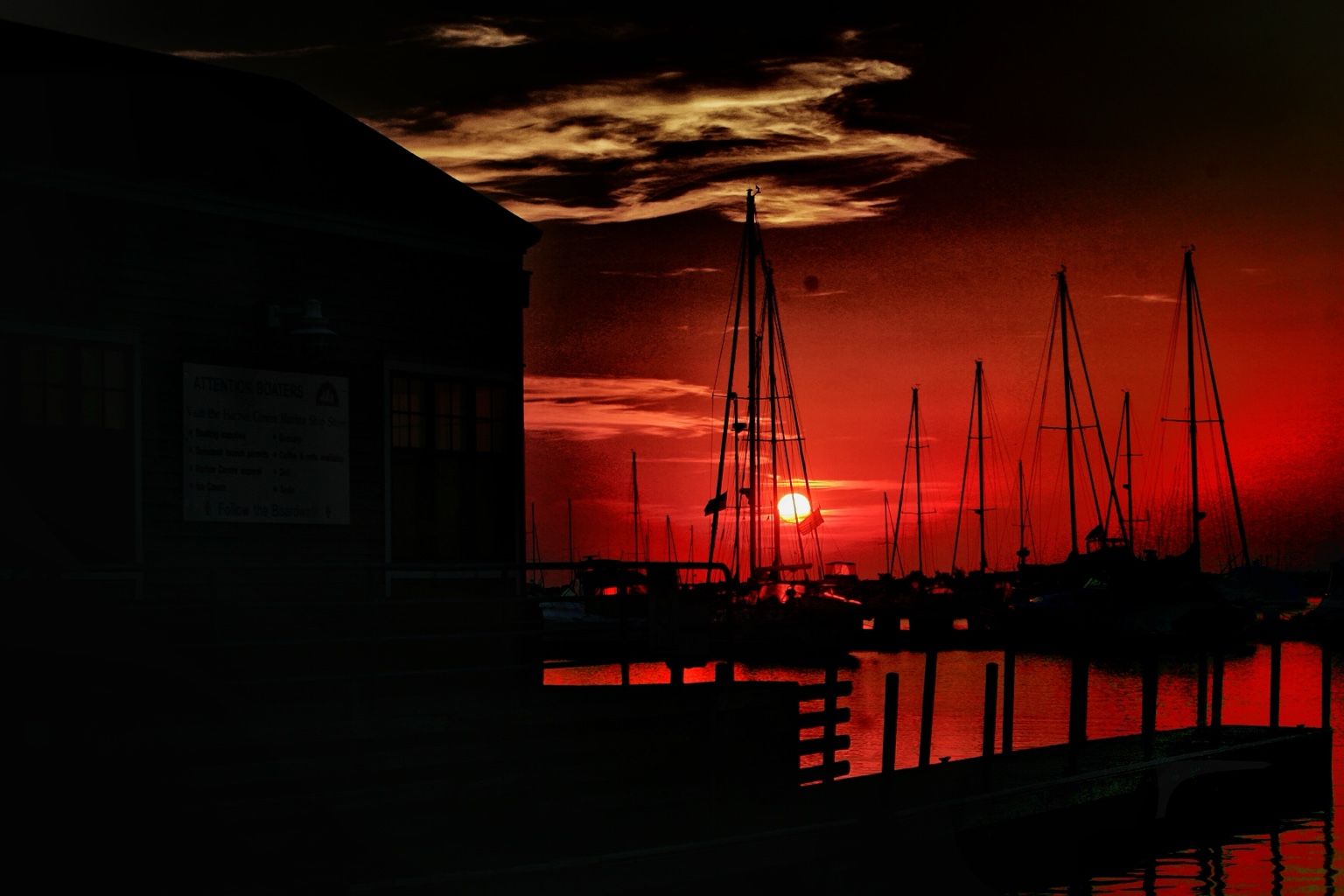 A deep red sunset behind boats in the Sheboygan harbor.