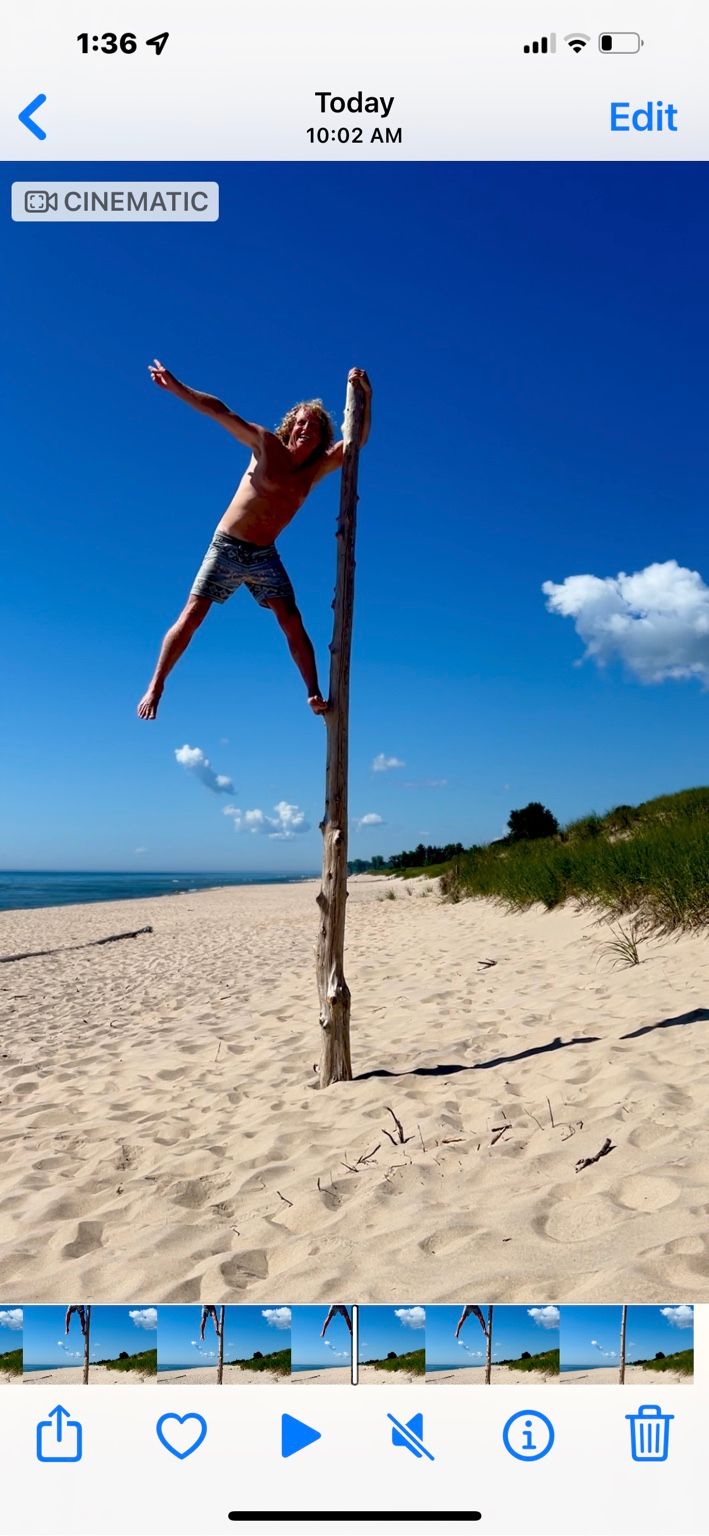 A person climbing a tall pole against a bright blue Sheboygan sky.
