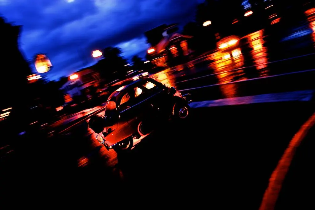 A race car in a neon motion-blur streak at night, Elkhart Lake Concourse.
