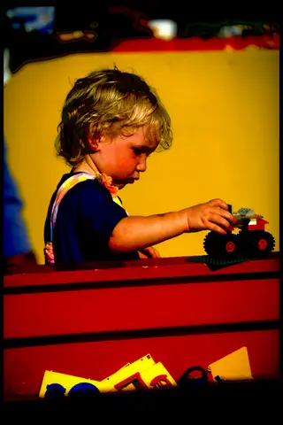 A toddler playing with a toy truck on a red box at Kohler-Andrae.