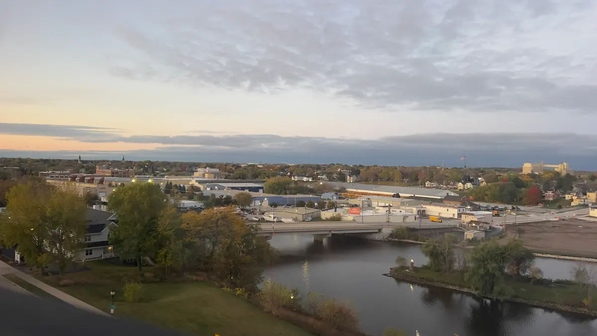 Early light over a river bend, a little island, and the city laid out flat.